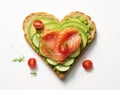 Delicious bread toasts in the shape of heart, with fresh avocado and red salted fish, on a white background