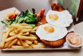 Delicious breaded beef dish with ham, cheese, fried eggs, accompanied by French fries. typical Argentine dish Royalty Free Stock Photo
