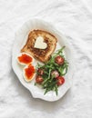Delicious breakfast, brunch - toasts with butter, boiled eggs with red caviar, fresh salad on a light background, top view Royalty Free Stock Photo
