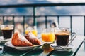 Delicious breakfast with coffee, pastry, and orange juice served on the balcony with sea view