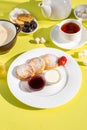 Delicious Breakfast with Cottage Cheese Pancakes, Oatmeal, Tea, Honey, Jam, Fruit on Yellow Table