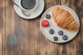 Delicious breakfast with cup of coffee and croissant with fresh berries on a wooden table. Top view and copy space Royalty Free Stock Photo