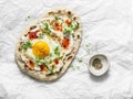 Delicious breakfast - flatbread with fried egg, greek yogurt, chili sauce and cheese on light background, top view Royalty Free Stock Photo