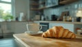 Delicious breakfast with fresh croissant and cup of hot drink in kitchen Royalty Free Stock Photo