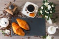 Delicious breakfast with fresh croissants and cup of coffee on wooden background. Royalty Free Stock Photo