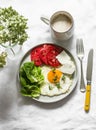 Delicious breakfast - fried egg, ripe tomatoes, greek cheese, green salad and coffee on a light background, top view Royalty Free Stock Photo