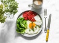 Delicious breakfast - fried egg, ripe tomatoes, greek cheese, green salad and coffee on a light background, top view Royalty Free Stock Photo