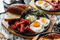 Delicious breakfast with fried eggs, slices of bread, sausage and salad of beans served on hot pan over wooden background. Healthy Royalty Free Stock Photo