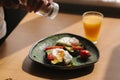 Delicious breakfast at home. Woman salt Sandwich with fresh sliced avocado above rye toasted bread with cherry tomatoes Royalty Free Stock Photo