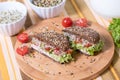 A healthy meal of whole wheat dark brown rye bread, curd cream cheese, radish, alfalfa sprouts, ham, tomatoes, green salad Royalty Free Stock Photo