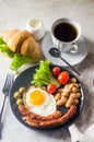 Delicious breakfast or lunch with fried eggs, ausages, beans, croissant and coffee