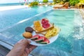 Delicious breakfast on luxury resort with swimming pool background Royalty Free Stock Photo