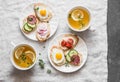 Delicious Breakfast - mini sandwiches with cream cheese, vegetables, quail eggs, salami and green tea with lemon and thyme. Sandwi