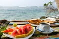 Delicious breakfast near the ocean. Sea waves in the background. Romantic getaway vacation in paradise. Colorful fruit plate with