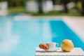 Delicious breakfast lemon, coffee, croissant by the pool Royalty Free Stock Photo