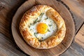 Delicious breakfast pastry with egg topping on rustic wooden plate Royalty Free Stock Photo