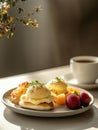 A delicious breakfast plate featuring eggs benedict, fruit, and coffee Royalty Free Stock Photo