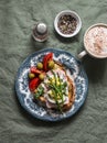 Delicious breakfast - sandwich with boiled egg, ham, asparagus, tomatoes, olives and cappuccino on the table, top view Royalty Free Stock Photo