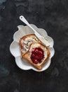 Delicious breakfast, snack - crispy toast with butter and cranberry jam on a dark background, top view