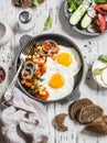 Delicious breakfast or snack - a fried egg, beans in tomato sauce with onions and carrots, fresh cucumbers and tomatoes, homemade