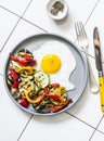 Delicious breakfast or snack - grilled vegetables and fried egg on a light background, top view Royalty Free Stock Photo