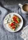 Delicious breakfast or snack - red caviar, avocado sandwiches and blue cheese on grey background Royalty Free Stock Photo