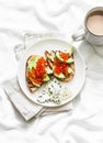 Delicious breakfast or snack - red caviar, avocado sandwiches and blue cheese on light background