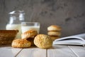 Delicious breakfast: sugar cookies, a glass of milk and a jug of milk on a white table. Close-up