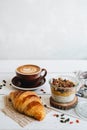 Delicious breakfast on the table. The cup of coffee, mango chia pudding and croissant at the white table Royalty Free Stock Photo