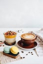 Delicious breakfast on the table. The cup of coffee, mango pudding and macarons at the white table Royalty Free Stock Photo