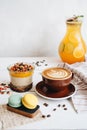 Delicious breakfast on the table. The cup of coffee, mango pudding and macarons at the white table Royalty Free Stock Photo