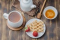 Delicious breakfast with tea, honey and wafers decorated with fresh strawberry on a wwoden table. Top view Royalty Free Stock Photo