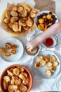 Delicious breakfast with tiny mini pancakes, cherries, apricots, jam on a white table. Small children hold pancakes in