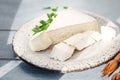 Delicious brie and camembert cheeses on a handmade clay kraft plate. Dairy French products. background blue board