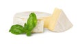 Delicious brie cheese with basil on white background