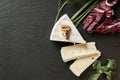 Delicious brie cheese on black background. Brie type of cheese. Camembert. Fresh Brie cheese and a slice on stone board. Italian,