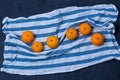 Delicious bright juicy mandarins Mandarin blue white striped kitchen towel fabric cloth on a dark blue black background for the wh