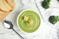 Delicious broccoli cream soup with croutons on white marble table, flat lay Royalty Free Stock Photo