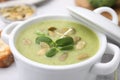 Delicious broccoli cream soup with pumpkin seeds in bowl, closeup