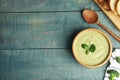 Delicious broccoli cream soup served on blue wooden table, flat lay. Space for text Royalty Free Stock Photo