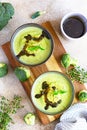 Delicious broccoli cream soup served with spicy oil and mint. Vegetarian dish. Top view. Light concrete background Royalty Free Stock Photo