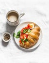 Delicious brunch - coffee with cream and croissant sandwich with cream cheese, salmon and boiled egg on a light background, top Royalty Free Stock Photo