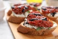 Delicious bruschetta with sun-dried tomato, cream cheese and balsamic vinegar on light table, closeup Royalty Free Stock Photo