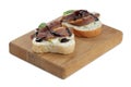 Delicious bruschettas with anchovies, eggs, basil and sauce on white background