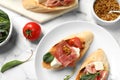 Delicious bruschettas with prosciutto served, flat lay