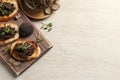 Delicious bruschettas with truffle sauce and microgreens on white wooden table, flat lay. Space for text Royalty Free Stock Photo