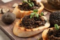 Delicious bruschettas with truffle sauce and microgreens on wooden board, closeup Royalty Free Stock Photo