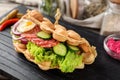 Delicious bubble waffle with fried egg and sausage slices on wooden board, closeup