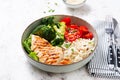 Delicious buddha bowl with grilled chicken, fresh vegetables and rice on a light background Royalty Free Stock Photo