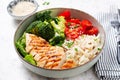 Delicious buddha bowl with grilled chicken, fresh vegetables and rice on a light background Royalty Free Stock Photo